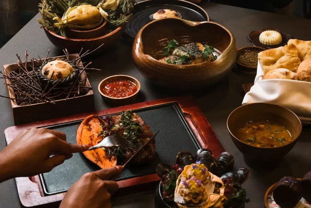 Argentinian dishes shared across a dining table at FIRE, ION Orchard